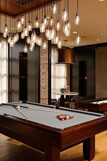 a pool table in a room with a bunch of lamps